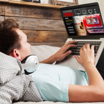 young man streaming movies online laptop headphones vpn services